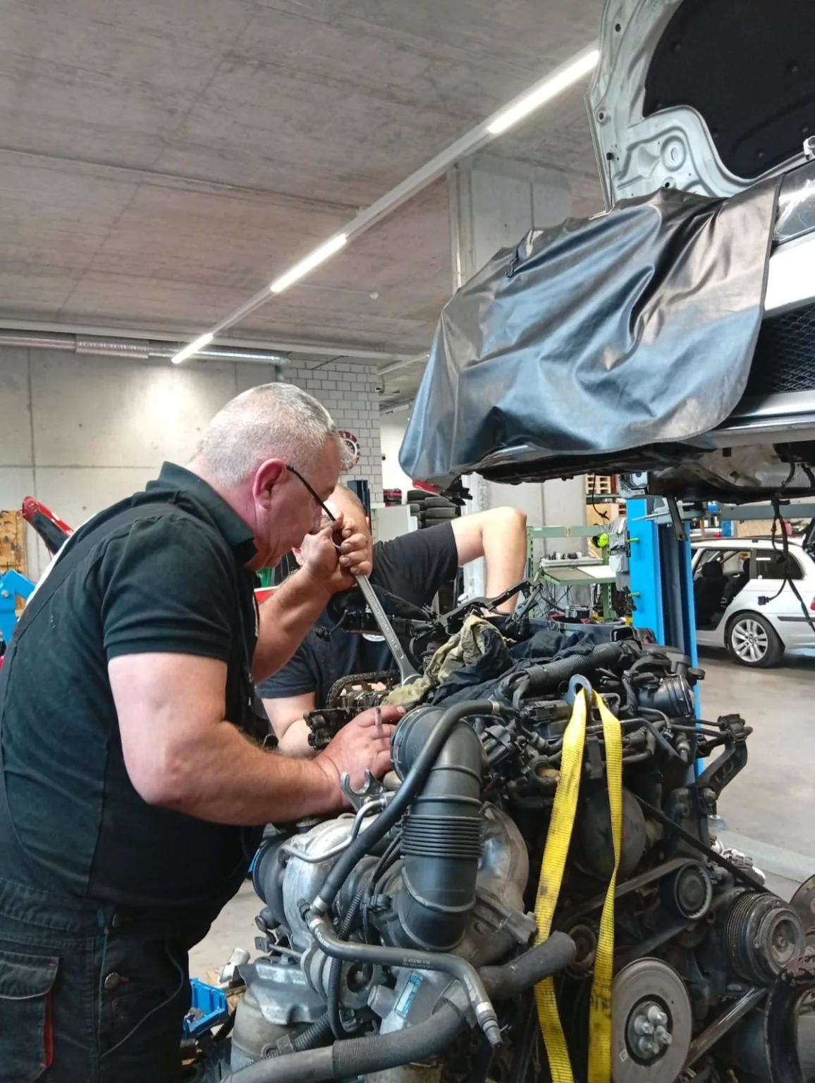 Reparatur und Diagnose im Motorraum eines roten Fahrzeugs