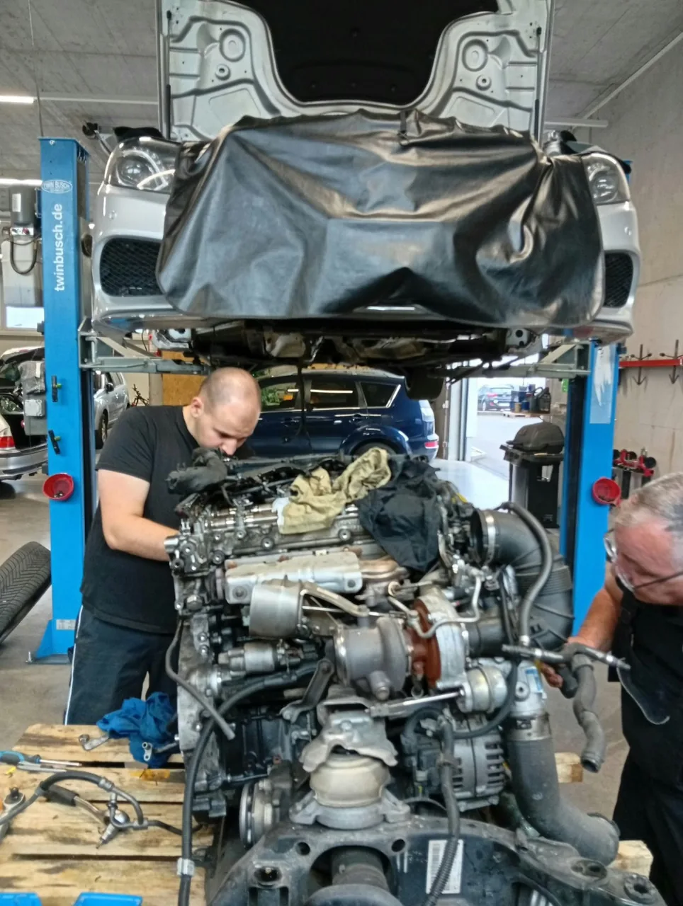 Raul und Iulian bei der Arbeit an einem ausgebauten Motor in der Phoenix Werkstatt